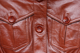 Close-up of soft brown leather jacket with buttons and front pockets