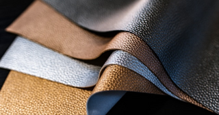 Close-up of textured real and faux leather swatches in metallic tones