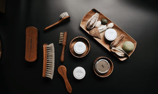 Leather jacket polishing kit with brushes, creams, and cloths on table