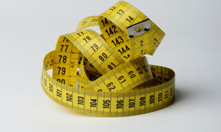 Yellow measuring tape coiled for leather jacket size guide