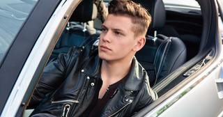 Stylish man in luxury car wearing a premium black leather jacket