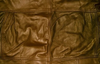 Wrinkled brown leather surface showing signs of aging and wear.