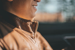 Close-up of man wearing brown leather jacket in sunlight