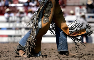 Rodeo cowboy wearing leather chaps with fringe for style and protection.